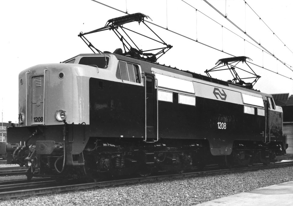 HUA-151156-Afbeelding van de electrische locomotief nr. 1208 (serie 1200) van de N.S. in nieuwe geel-grijze huisstijl bij de hoofdwerkplaats van de N.S. te Tilburg