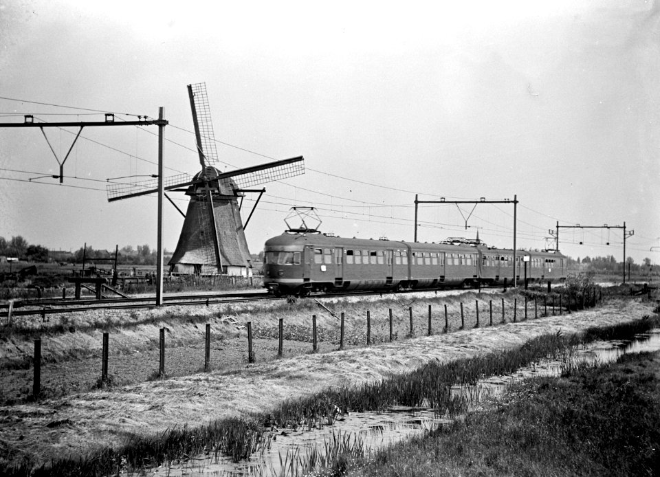 HUA-150902-Afbeelding van een electrisch treinstel mat 1946 van de NS ter hoogte van Hazerswoude met een molen