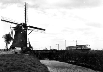 HUA-151020-Gezicht op een molen ter hoogte van Hazerswoude met op de achtergrond een electrisch treinstel mat. 1964 (plan V) van de N.S