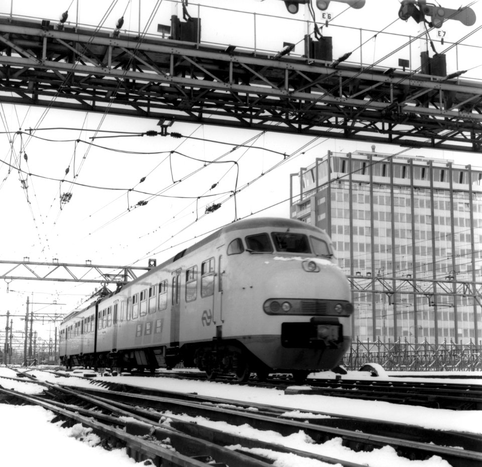 HUA-171809-Afbeelding van een electrisch treinstel mat. 1964 (plan V) van de N.S. onder seinbrug (westzijde) te Amsterdam C.S