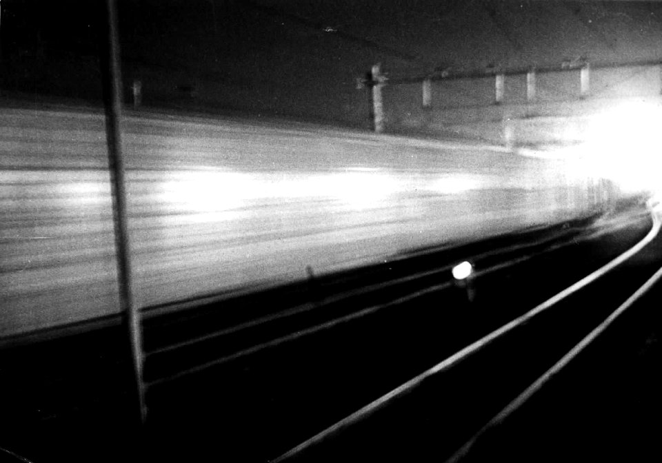 HUA-150970-Afbeelding van een voorbijsnellende electrische trein bij avond