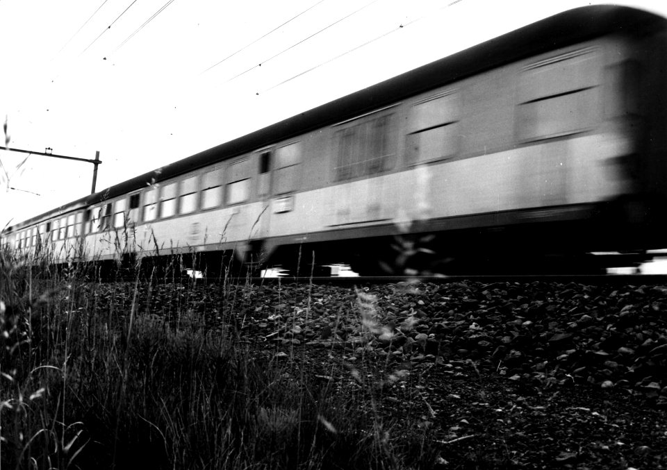 HUA-151033-Afbeelding van een voorbijsnellende trein met internationale rijtuigen van de Deutsche Bundesbahn (D.B.) ter hoogte van Arnhem
