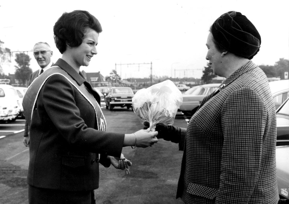 HUA-171847-Afbeelding van de opening van het nieuwe N.S.-station Haren te Haren, met links N.S.-ambassadrice Jeanne Vollemans die mevr. Van Ketwich Verschuur (echtgenote van de burgemeester) een bosje bloemen aa