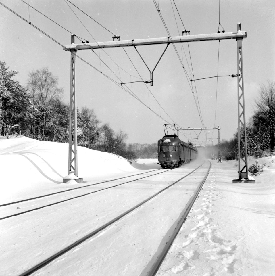HUA-150915-Afbeelding van electrische treinstellen mat. 1946 van de N.S. in een sneeuwlandschap met bomen ter hoogte van Hulshorst
