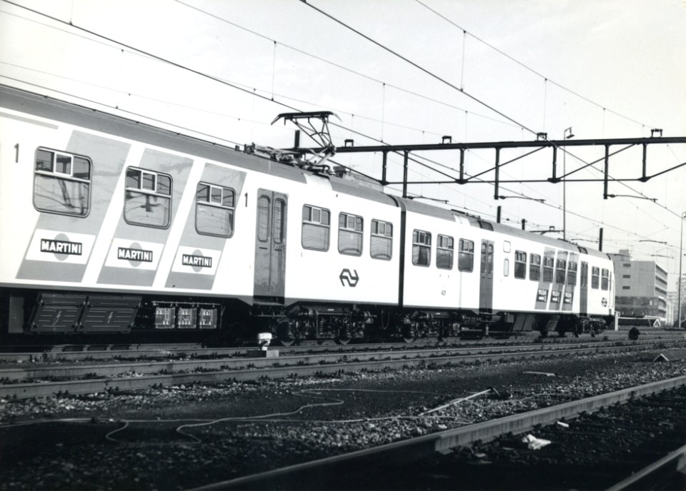 HUA-170702-Afbeelding van het electrische treinstel nr. 431 (Plan V, mat. 1964) van de N.S. tijdens de presentatie van de nieuwe, gele huisstijl met blauwe diagonale reclamebanden voor treinstellen te Rotterdam