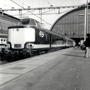 HUA-168176-Afbeelding van een electrische Benelux trek-duweenheid van de N.S. en de N.M.B.S. langs het perron van het N.S.-station Amsterdam C.S. te Amsterdam