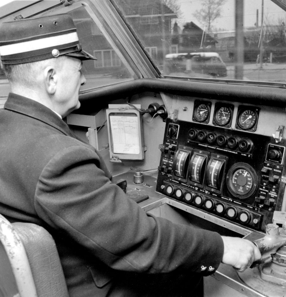 HUA-171723-Afbeelding van een machinist in de cabine (stuurstand) van een electrisch treinstel Plan P (mat. 1954) van de N.S., tijdens doorkomst te Bunnik