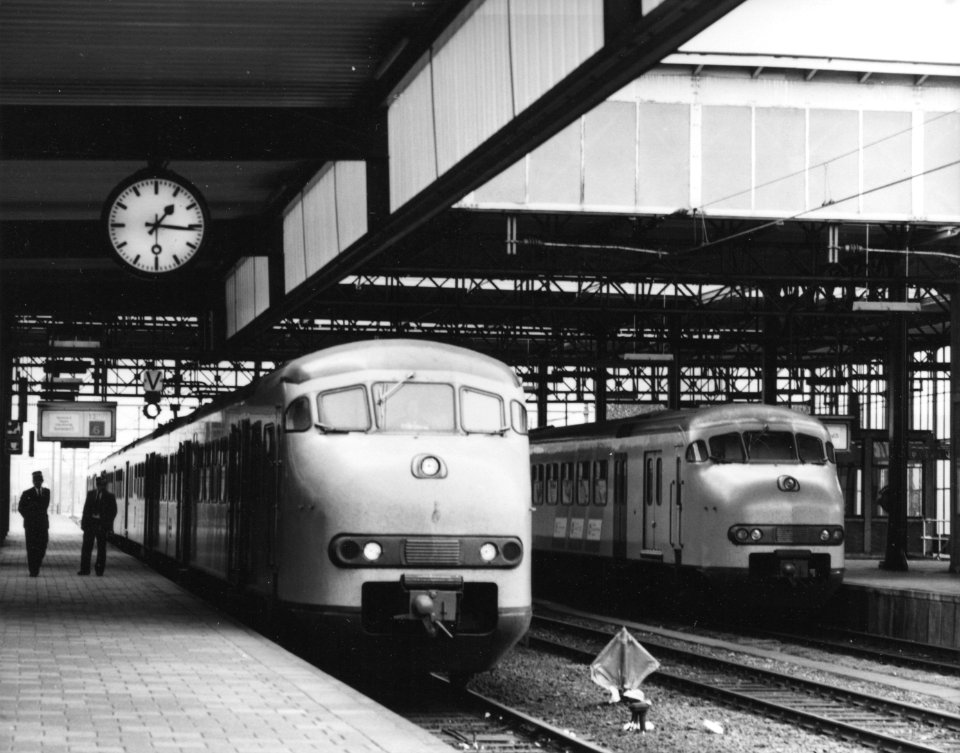 HUA-171408-Afbeelding van een electrisch treinstel mat. 1964 (plan T) langs het tweede perron van het N.S.-station Leiden te Leiden, met rechts een treinstel plan V