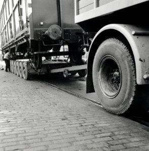 HUA-168089-Afbeelding van het vervoer van een goederenwagen van de N.S. op een oplegger van een vrachtauto ("wagon trailer" of "rolwagenvervoer") te Eindhoven