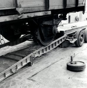 HUA-168105-Afbeelding van het vervoer van een goederenwagen van de N.S. op een oplegger van een vrachtauto ("wagon trailer" of "rolwagenvervoer") te Eindhoven