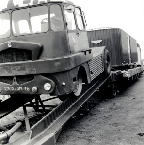 HUA-168079-Afbeelding van het plaatsen van een oplegger van een vrachtauto op een speciale wagon van de SNCF zg Kangourou of Huckepack vervoer op het terrein van