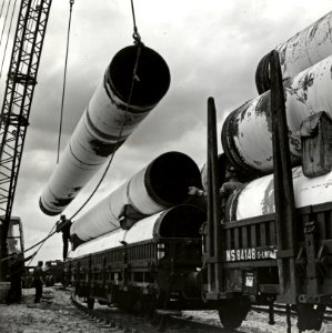 HUA-171238-Afbeelding van het overladen van gasbuizen te Tiel ten behoeve van de aanleg van het landelijke aardgasnetwerk
