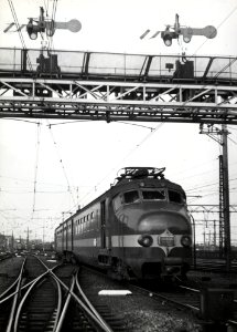 HUA-168259-Afbeelding van een electrisch treinstel mat. 1954 (Benelux) van de N.S.-N.M.B.S. onder de seinbrug van het N.S.-station Amsterdam C.S. te Amsterdam