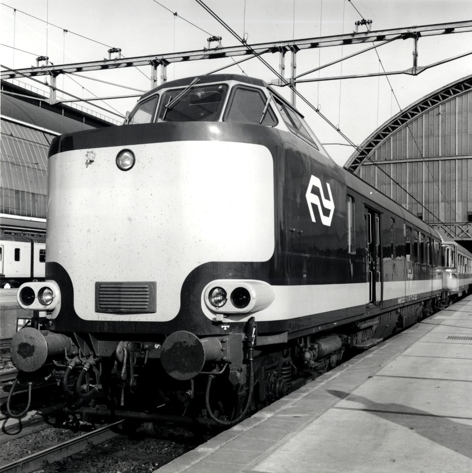 HUA-168177-Afbeelding van het stuurstandrijtuig 6184 87 38 101 3 van de NS wRDk ex plan D van een electrische Benelux trek duweenheid van de NS en de NMBS langs 