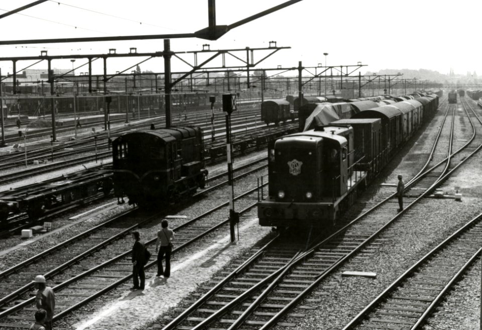HUA-171433-Gezicht op het emplacement te Venlo met rechts de diesel-electrische locomotief nr. 2413 (serie 2400-2500) van de N.S. tijdens rangeren en links een diesel-electrische rangeerlocomotief uit de serie 500-600