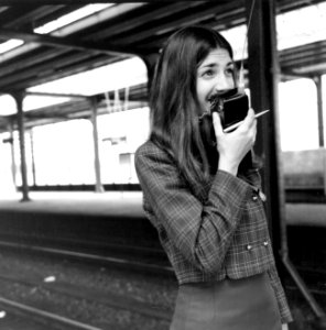 HUA-171697-Afbeelding van een hostess van de N.S. met walkie talkie op het perron van het N.S.-station Amsterdam Amstel te Amsterdam