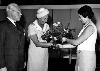 HUA-171867-Afbeelding van de opening van het nieuwe N.S.-station Vlaardingen West te Vlaardingen, met links burgemeester mr. J. Heusdens en rechts N.S.-ambassadrice Jeanne Vollemans die bloemen overhandigt aan m