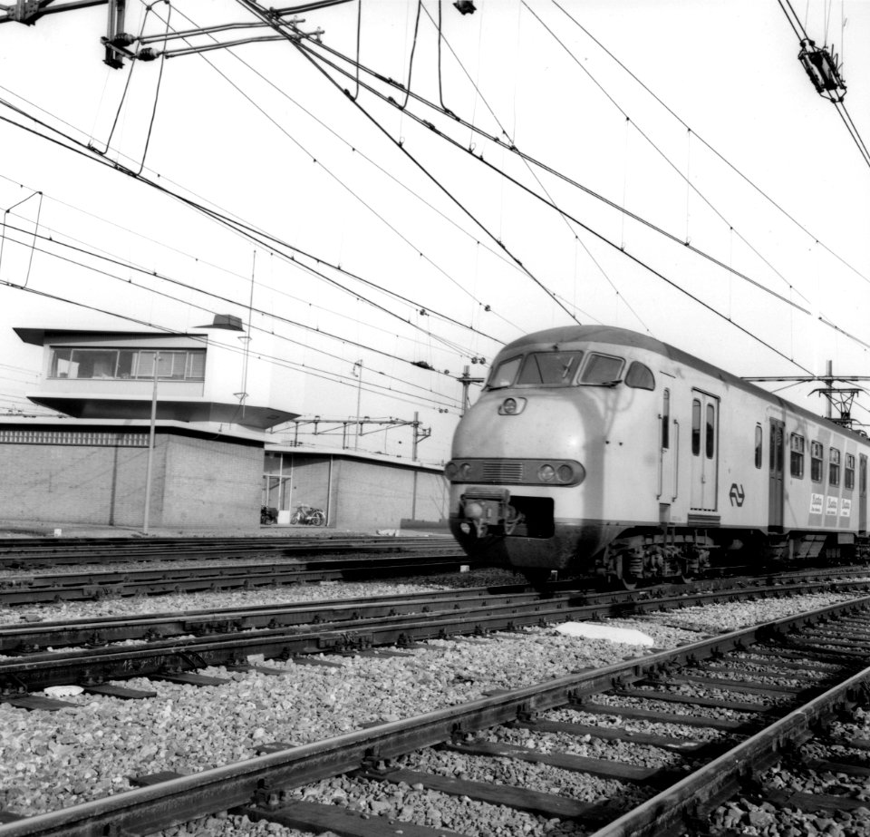 HUA-171808-Afbeelding van een electrisch treinstel mat. 1964 (plan V) van de N.S. te Amersfoort, met links het seinhuis (NX-post)
