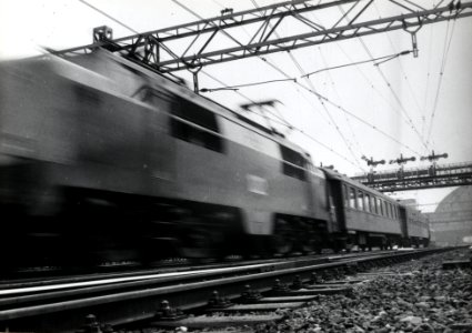 HUA-168273-Afbeelding van een internationale trein D trein getrokken door een electrische locomotief uit de serie 1200 van de NS bij vertrek uit Amsterdam CS