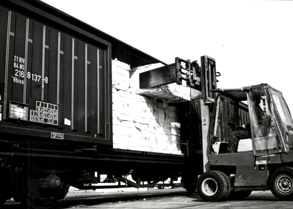 HUA-171227-Afbeelding van het beladen van goederenwagens (schuifwandwagen) type Hbiss van de N.S. met behulp van een heftruck met papier te Eerbeek