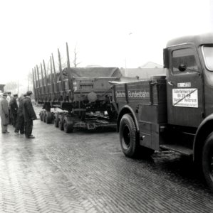 HUA-168044-Afbeelding van een vrachtauto van de Deutsche Bundesbahn (D.B.) met een aanhangwagen waarop een spoorwagon (rongenwagen) vervoerd wordt ("Strassenroller") te Wormerveer