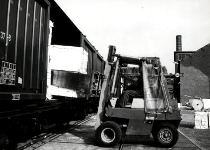 HUA-171228-Afbeelding van het beladen van goederenwagens (schuifwandwagen) type Hbiss van de N.S. met behulp van een heftruck met papier te Eerbeek