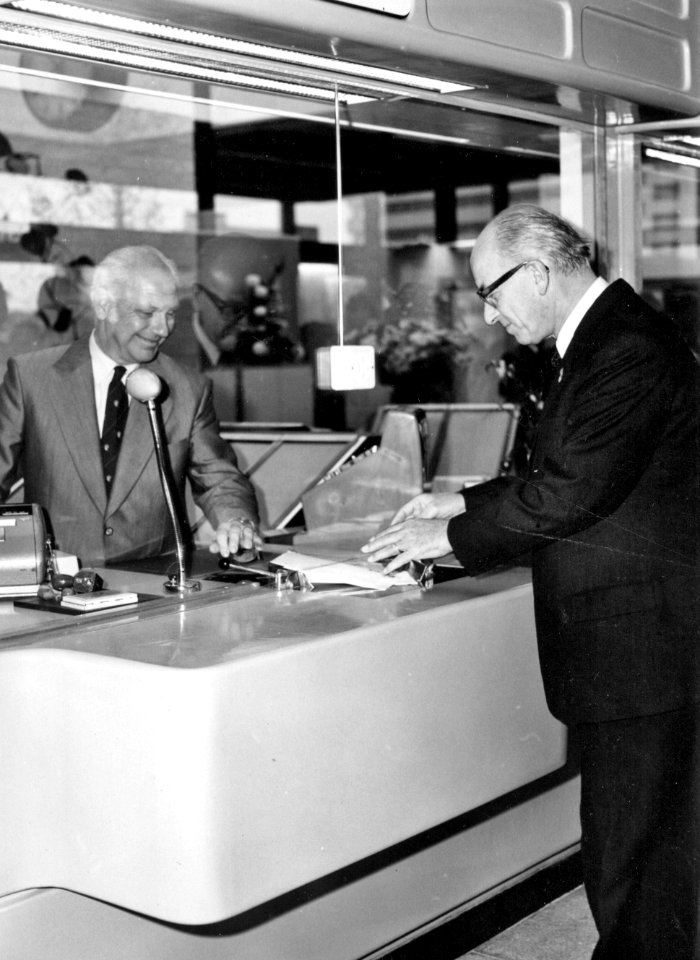 HUA-171531-Afbeelding van burgemeester mr TMJ de Graaf rechts van Nijmegen in het plaatskaartenkantoor van het NS station Nijmegen te Nijmegen tijdens de officië