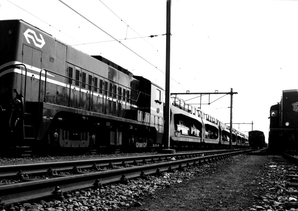 HUA-159897-Afbeelding van de diesel-electrische locomotief nr. 2333 (serie 2200-2300) van de N.S. met een goederentrein (autotrailers beladen met Peugeot's) op het goederenemplacement Utrecht V te Utrecht. Recht