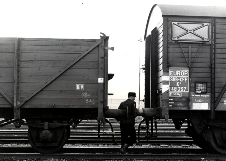 HUA-159877-Afbeelding van een rangeerder van de NS tussen twee goederenwagens op het goederenemplacement Amsterdam Rietlanden te Amsterdam