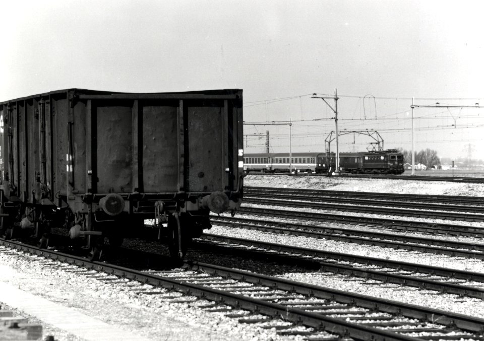 HUA-170250-Gezicht op het rangeerterrein Kijfhoek bij Rotterdam, met op de achtergrond een internationale trein, getrokken door een electrische locomotief uit de serie 1100 van de N.S. op de spoorlijn Rotterdam-