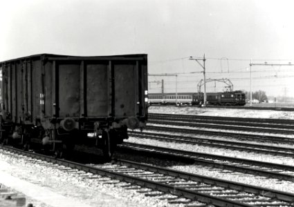 HUA-170250-Gezicht op het rangeerterrein Kijfhoek bij Rotterdam, met op de achtergrond een internationale trein, getrokken door een electrische locomotief uit de serie 1100 van de N.S. op de spoorlijn Rotterdam-