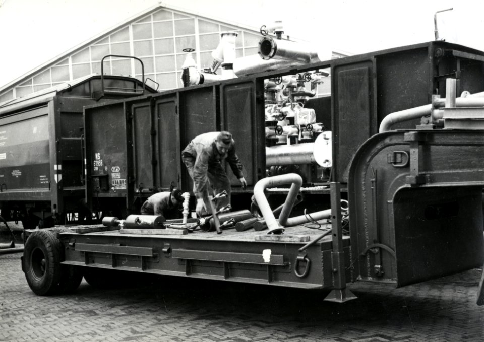 HUA-171247-Afbeelding van het vervoer van een oliestookinstallatie van de firma Boers en Vrijland (naar Roemenië) met een open goederenwagen (type GTOW) van de N.S. te 's-Gravenzande