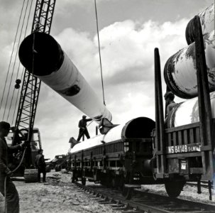 HUA-171236-Afbeelding van het overladen van gasbuizen te Tiel ten behoeve van de aanleg van het landelijke aardgasnetwerk