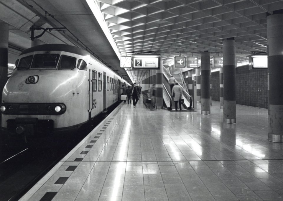 HUA-170816-Afbeelding van een electrisch treinstel plan T (mat. 1964) van de N.S. langs het perron van het N.S.-station Schiphol