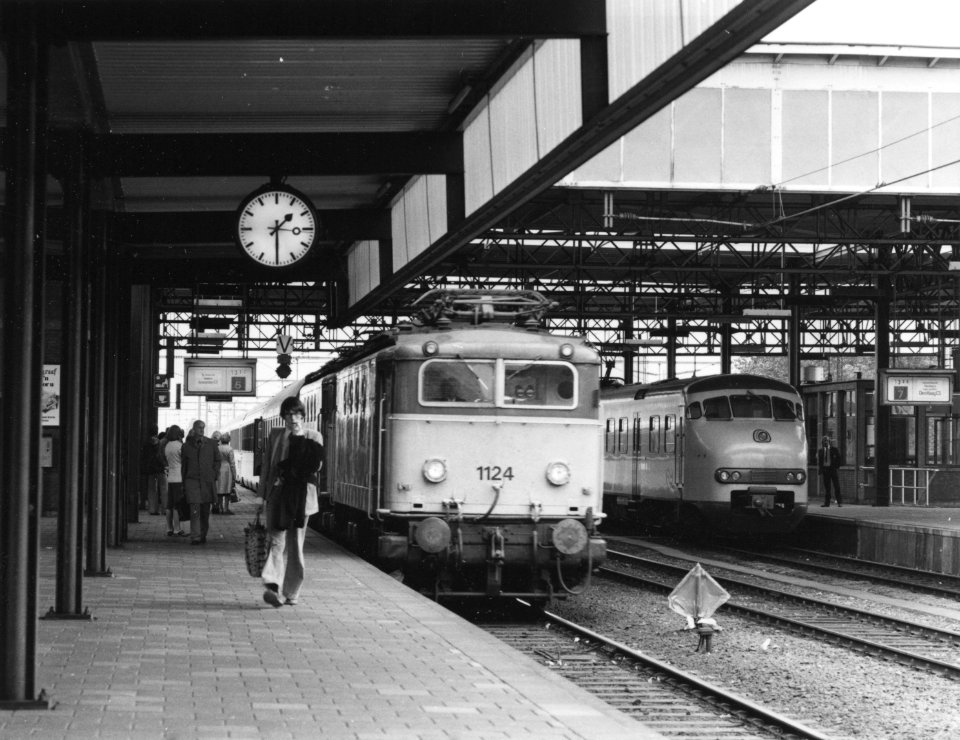 HUA-171410-Afbeelding van de electrische locomotief nr. 1124 (serie 1100) van de N.S. met een internationale trein langs het tweede perron van het N.S.-station Leiden te Leiden