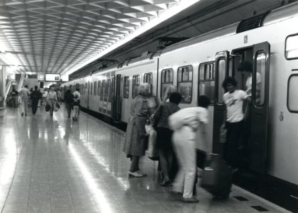 HUA-170813-Afbeelding van een electrisch treinstel plan T mat 1964 van de NS langs het perron van het NS station Schiphol met in en uitstappende reizigers