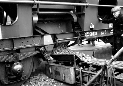 HUA-159810-Afbeelding van het lossen van steenkolen uit een zelflosser (type Fds) van de N.S. te Arnhem met behulp van een transportband