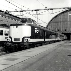 HUA-168174-Afbeelding van een electrische Benelux trek duweenheid van de NS en de NMBS langs het perron van het NS station Amsterdam CS te Amsterdam