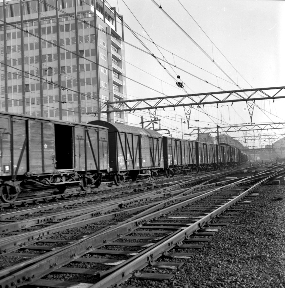 HUA-159865-Afbeelding van een passerende goederentrein op het emplacement Westelijk Eiland bij het N.S.-station Amsterdam C.S. te Amsterdam