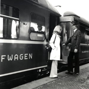 HUA-168165-Afbeelding van een treinreizigster bij een slaapwagen van Wagons-Lits in de Showtrein '72 te 's-Hertogenbosch, met rechts een steward van de D.S.G. (Deutsche Schlafwagen- und Speisewagen Gesellschaft)