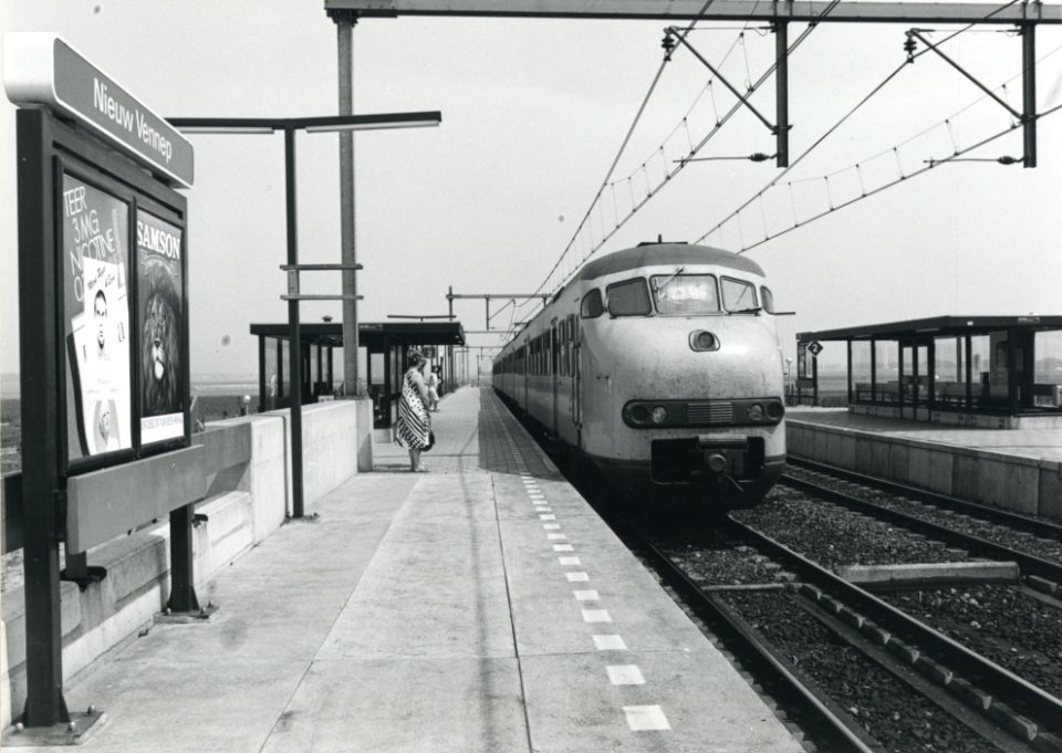 HUA-170800-Afbeelding van een electrisch treinstel plan T (mat. 1964) van de N.S. langs het perron van het N.S.-station Nieuw Vennep