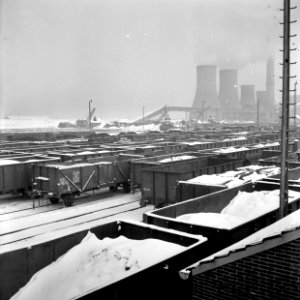 HUA-159805-Gezicht op het besneeuwde emplacement van de NS te Heerlen met rechts op de achtergrond de koeltorens van de Oranje Nassau mijn