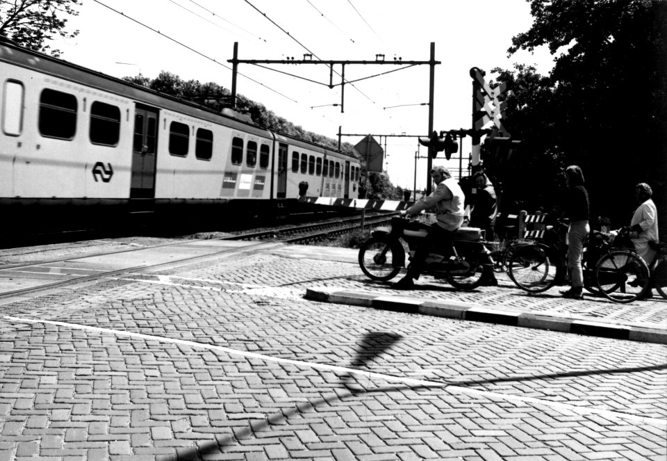 HUA-159992-Gezicht op een met AHOB's beveiligde spoorwegovergang te Voorburg tijdens het passeren van een trein