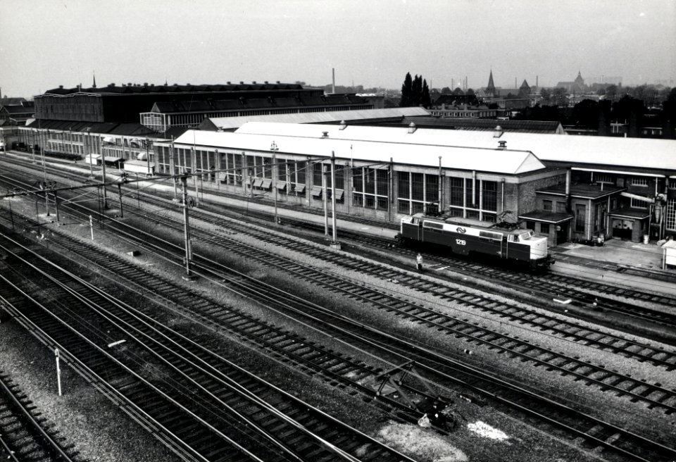 HUA-169910-Gezicht op de hoofdwerkplaats van de N.S. te Tilburg, met rechts de electrische locomotief nr. 1219 (serie 1200) van de N.S