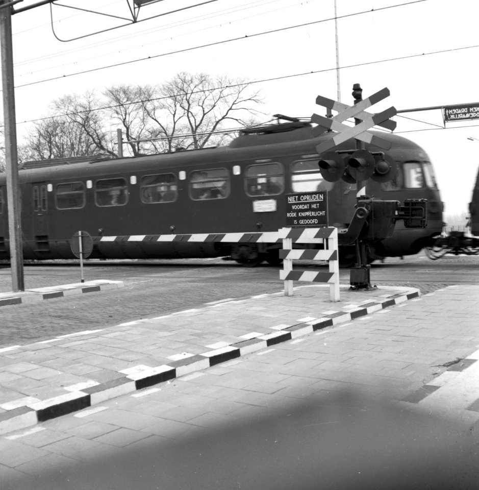 HUA-159951-Gezicht op een met AHOB's beveiligde spoorwegovergang te De Vink bij Leiden tijdens het passeren van een trein bestaande uit electrische treinstellen mat. 1946 van de N.S