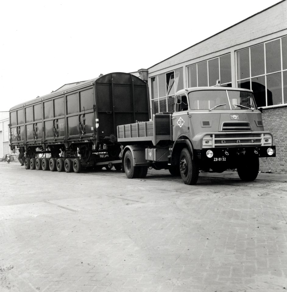 HUA-168097-Afbeelding van het vervoer van een goederenwagen van de N.S. op een oplegger van een vrachtauto ("wagon trailer" of "rolwagenvervoer") te Eindhoven