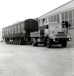 HUA-168097-Afbeelding van het vervoer van een goederenwagen van de N.S. op een oplegger van een vrachtauto ("wagon trailer" of "rolwagenvervoer") te Eindhoven