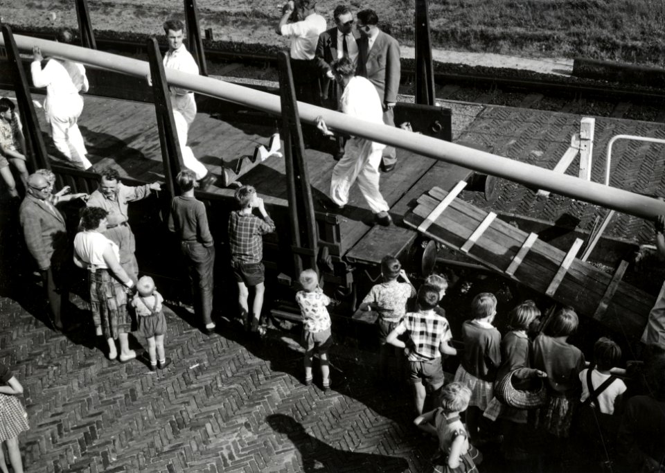 HUA-171252-Afbeelding van het beladen van goederenwagens (rongenwagens) met drie 110 meter lange, plastic buizen van de firma Wavin te Hardenberg voor transport naar Rotterdam
