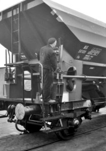 HUA-159809-Afbeelding van een losser op het bordes van een open zelflosser (type Fds) van de N.S. te Arnhem