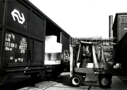 HUA-171226-Afbeelding van het beladen van goederenwagens schuifwandwagen type Hbis w van de NS met behulp van een heftruck met papier te Eerbeek